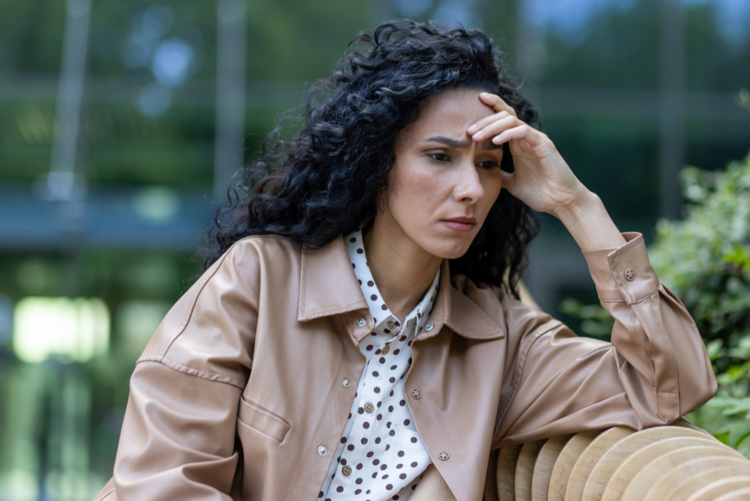 Woman sits anxiously on Bench