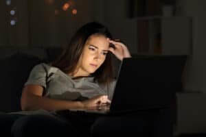 Teenage girl struggling with work on her laptop