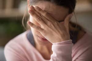 Woman holding her hand to her forehead with worry