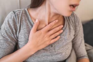 Woman with hand over chest scared