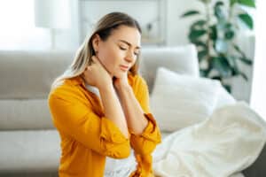 Woman holding neck in pain