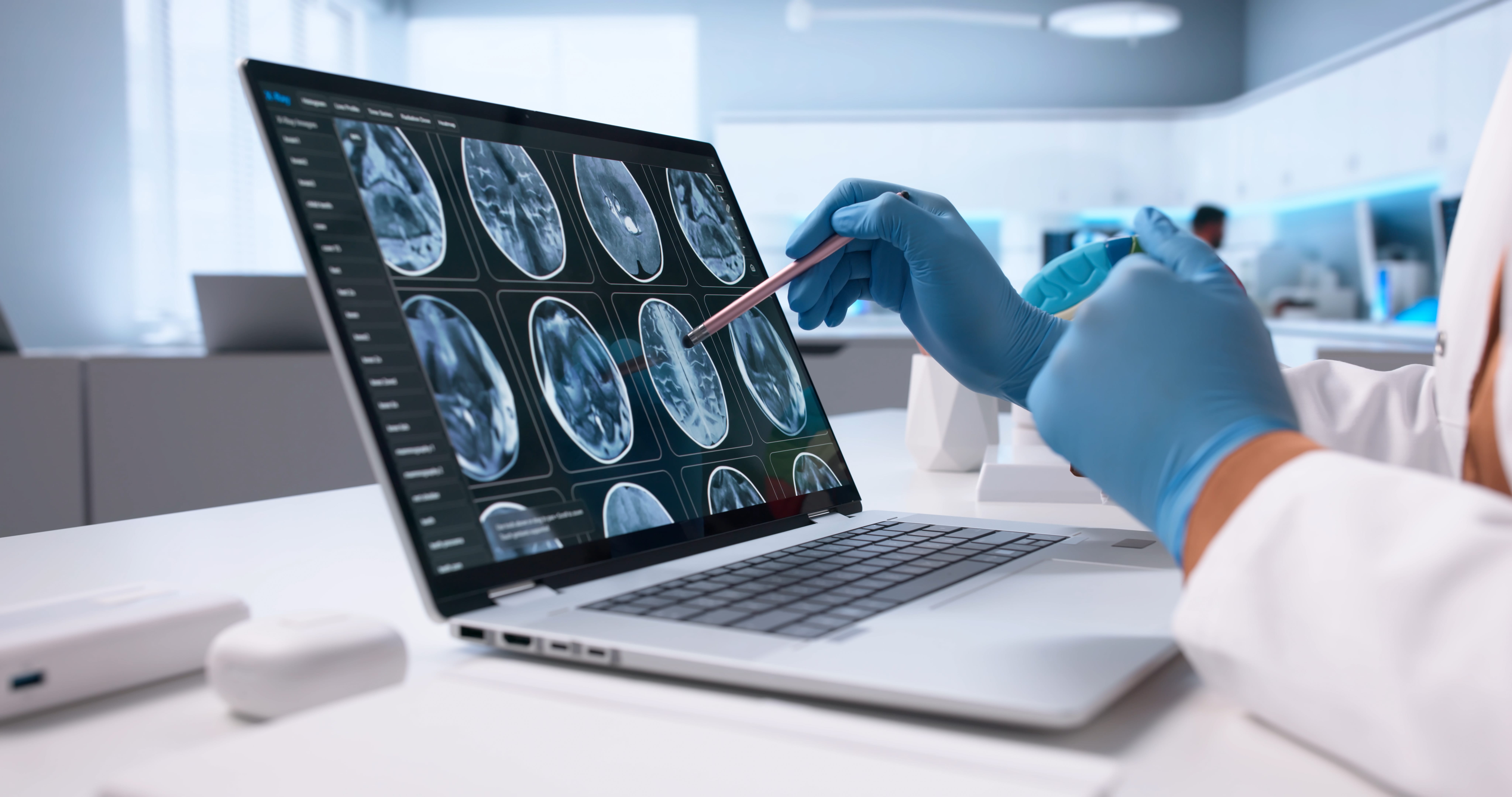 Radiologist examining brain scan images on multiple computer monitors in medical imaging facility