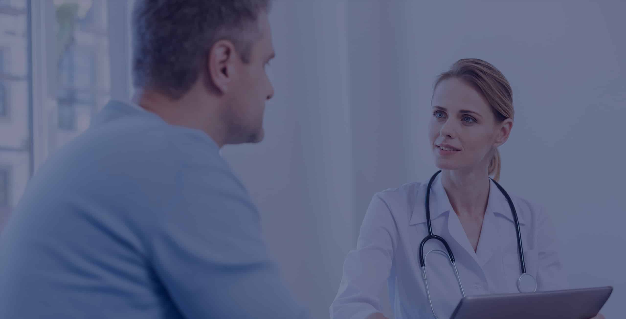 Patient consulting a physician at the front desk of a clinic.